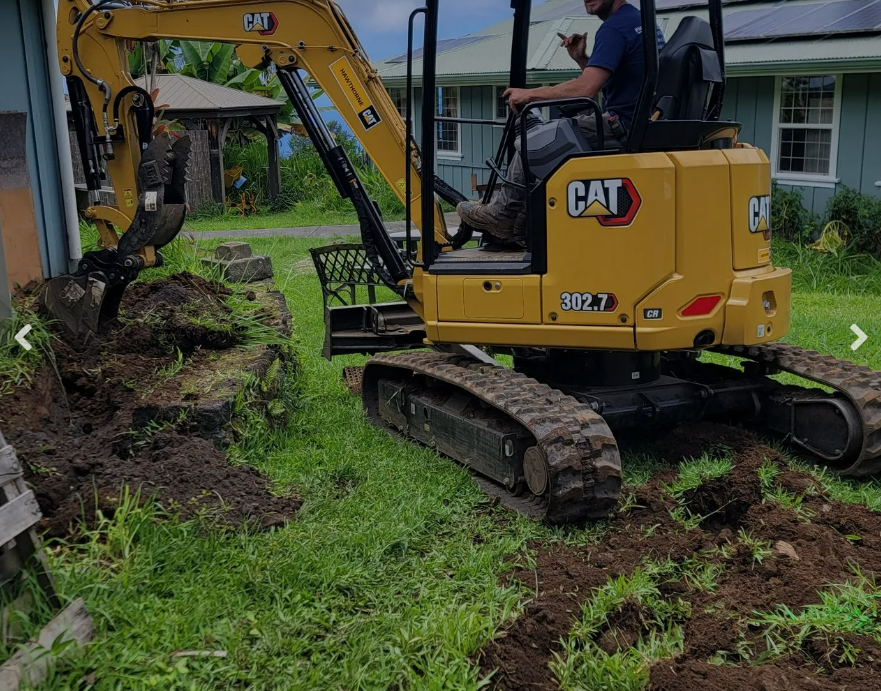 CAT 302.7 mini excavator digging for water catchment installation Hawaii