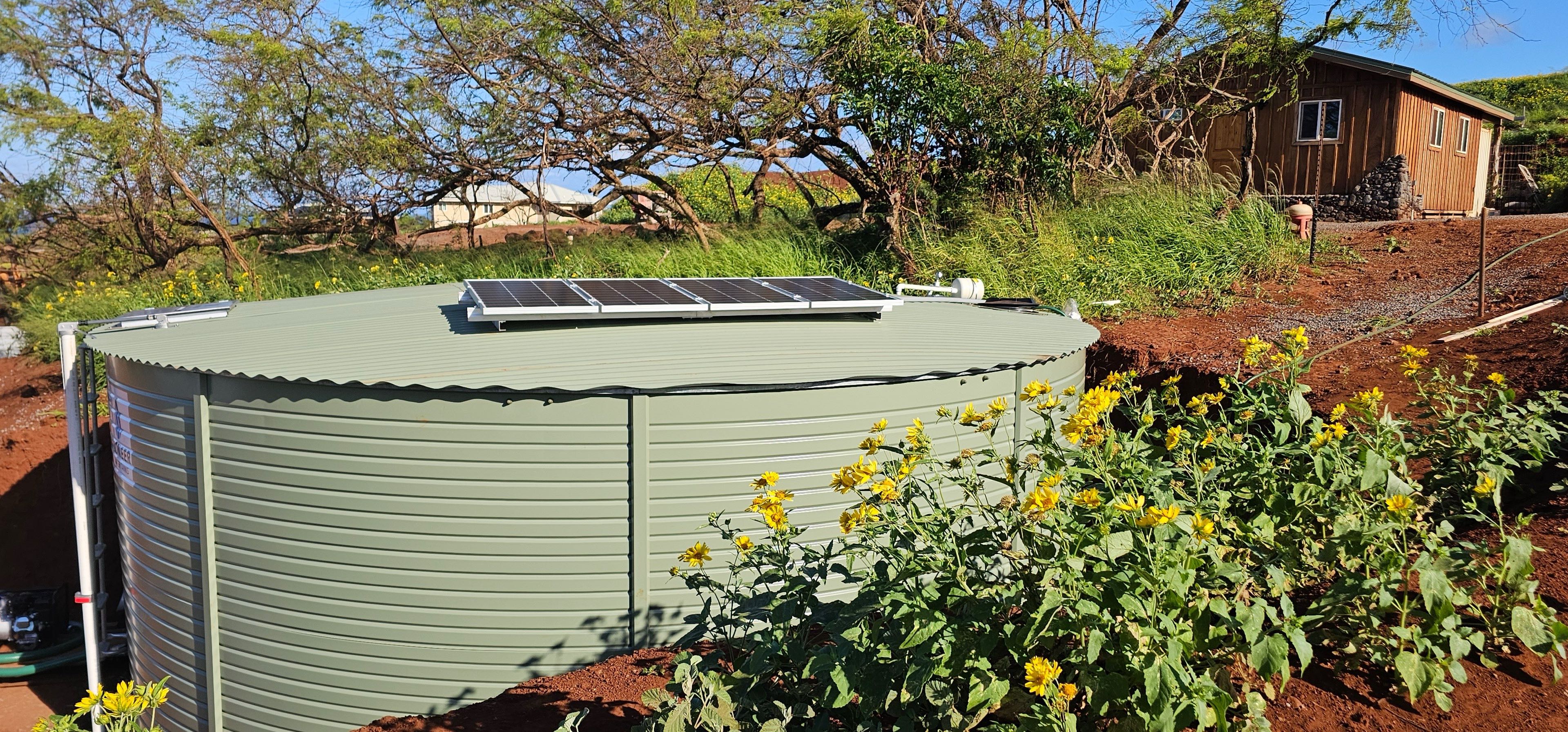 Pioneer water tank with solar panels installed on Hawaii ranch land
